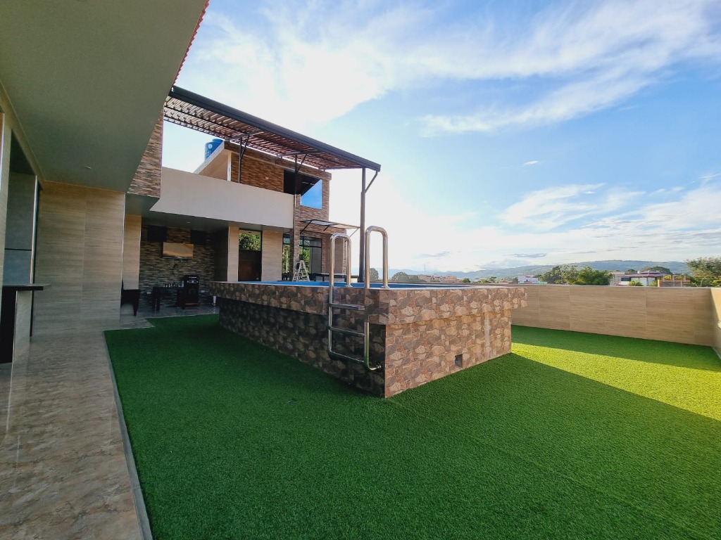 Terraza de césped sintético al lado de la piscina