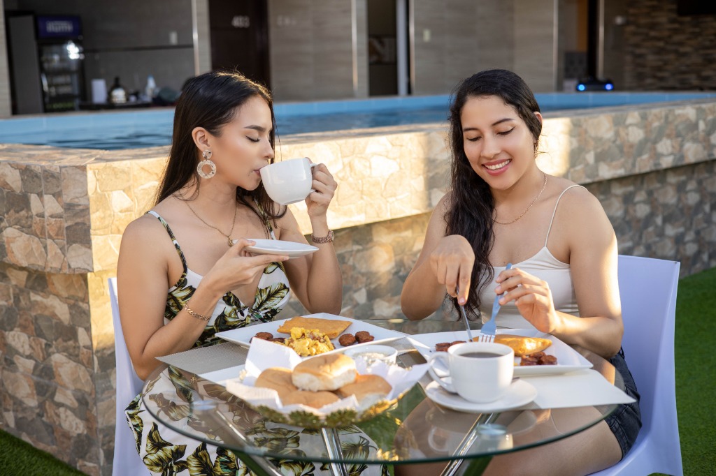 Huéspedes disfrutando del desayuno al lado de la piscina